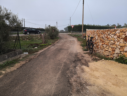 Incrocio con muretto in pietra e bicicletta