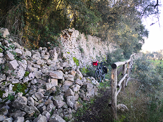 La bicicletta tra steccati e muri in pietra