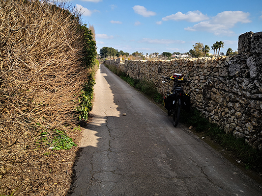 Alti muri in pietra e bicicletta