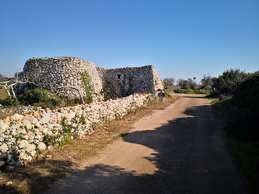 Pagliara con muro in pietra e bicicletta