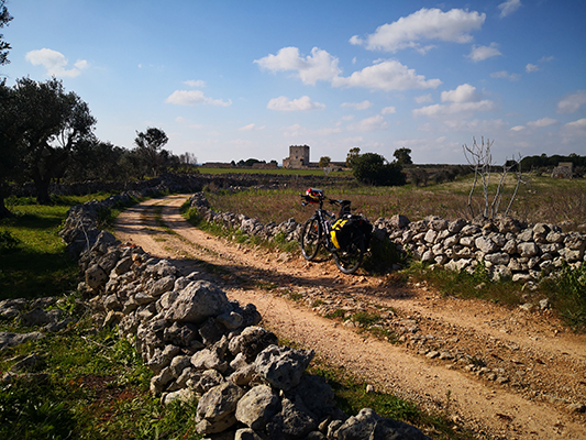 Strada gravel tra muri in pietra e bicicletta